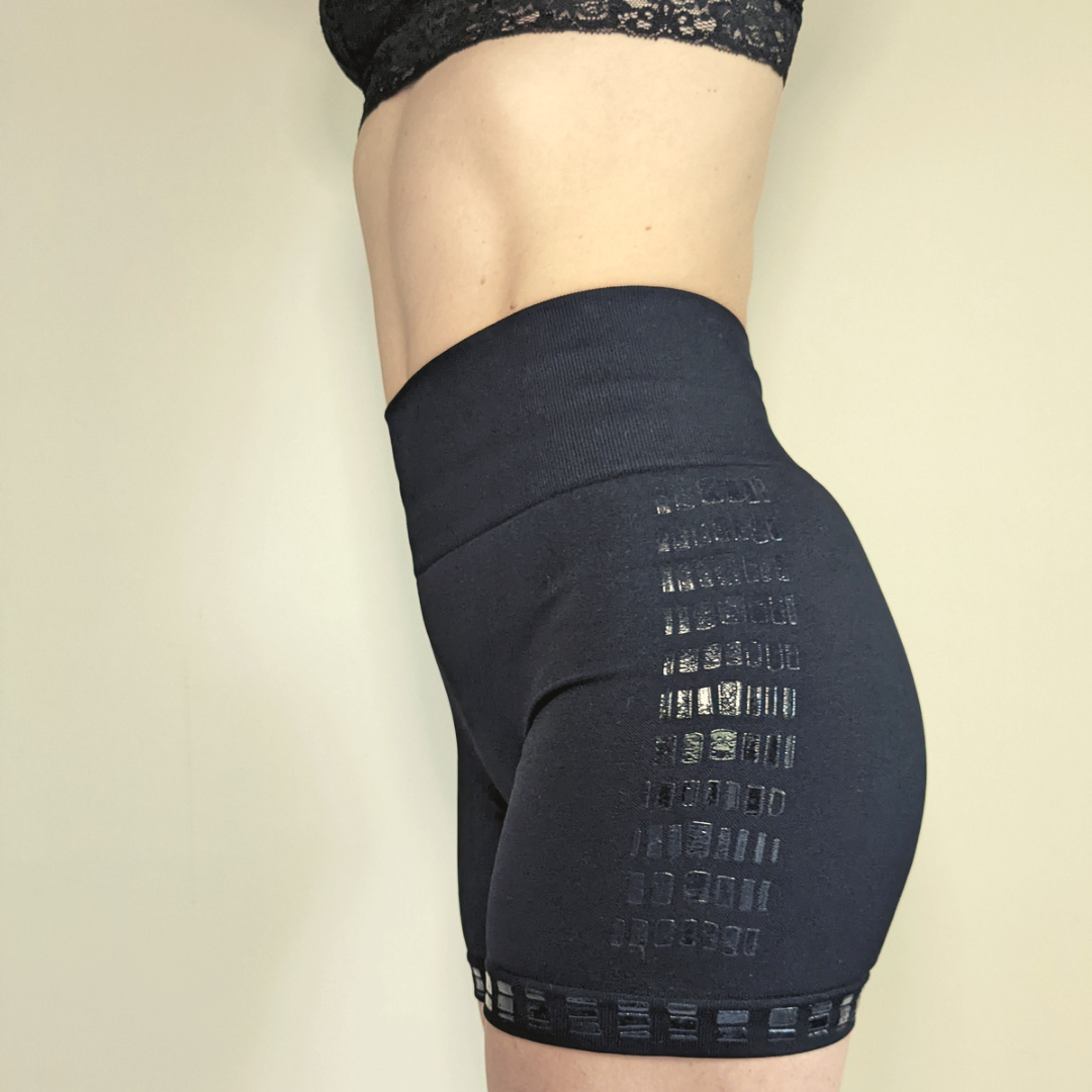 Model wearing Love Saia non slip slip shorts in black, side view.