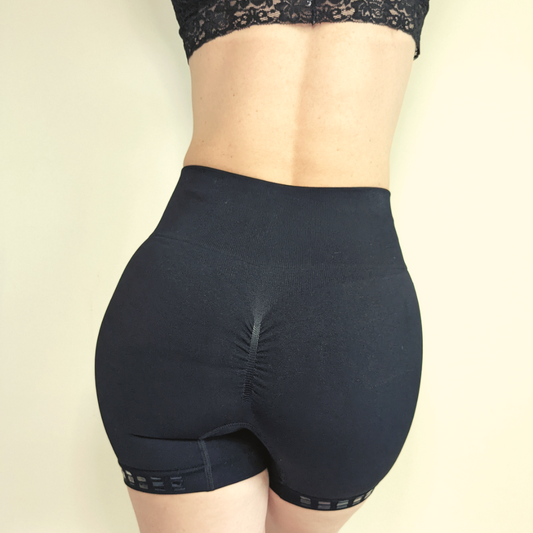Model wearing Love Saia non slip slip shorts in black, view from the back showing scrunch bum detail.